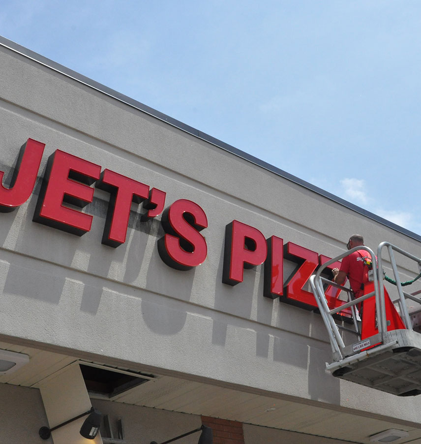 Jets Pizza building sign getting installed