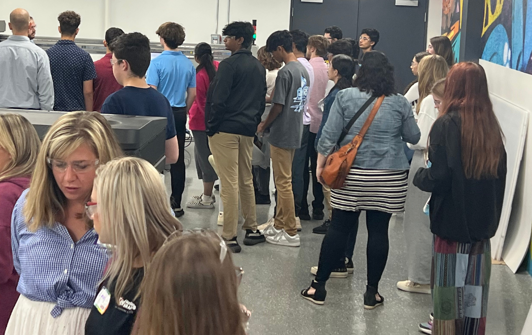 Group of high school students in a sign manufacturing facility